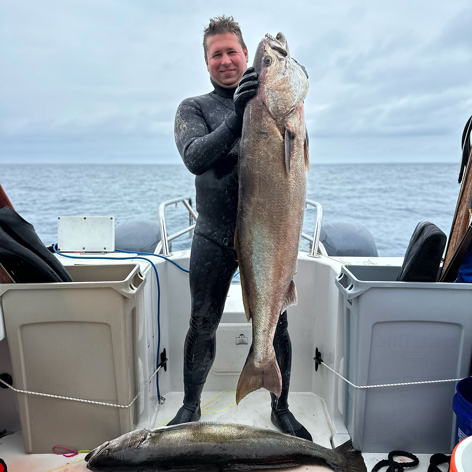 Co-owner/guide Mike Raabe holding up large white seabass