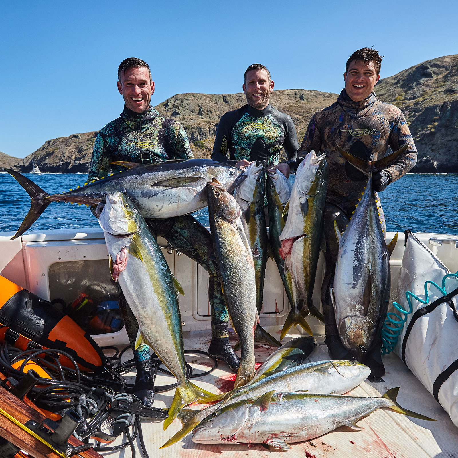 Spearfishermen showing off their many yellowtail catches